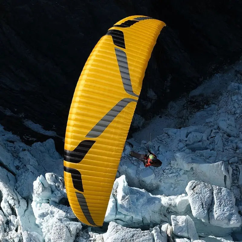 Ozone Swift 6 (High EN-B) beim Paragliding über verschneite Berge, ideal für erfahrene Hobbyflieger und XC-Piloten, bekannt für Agilität und Stabilität.