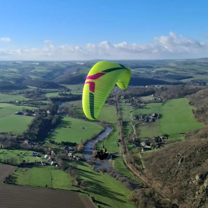 Ozone Swift 6 (High EN-B) Paraglider über einem Tal, ideal für erfahrene Pilot:innen, bietet beeindruckende Agilität und Leistung im Luftsport.