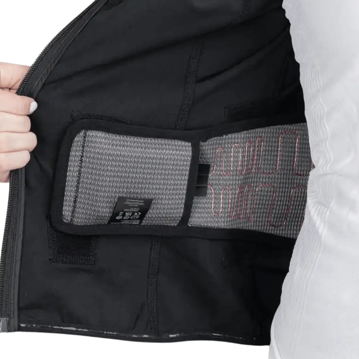 Detailansicht der Innenseite der schwarzen Lenz HEAT Vest 1.2 mit sichtbaren Heizelementen und einem Etikett.
