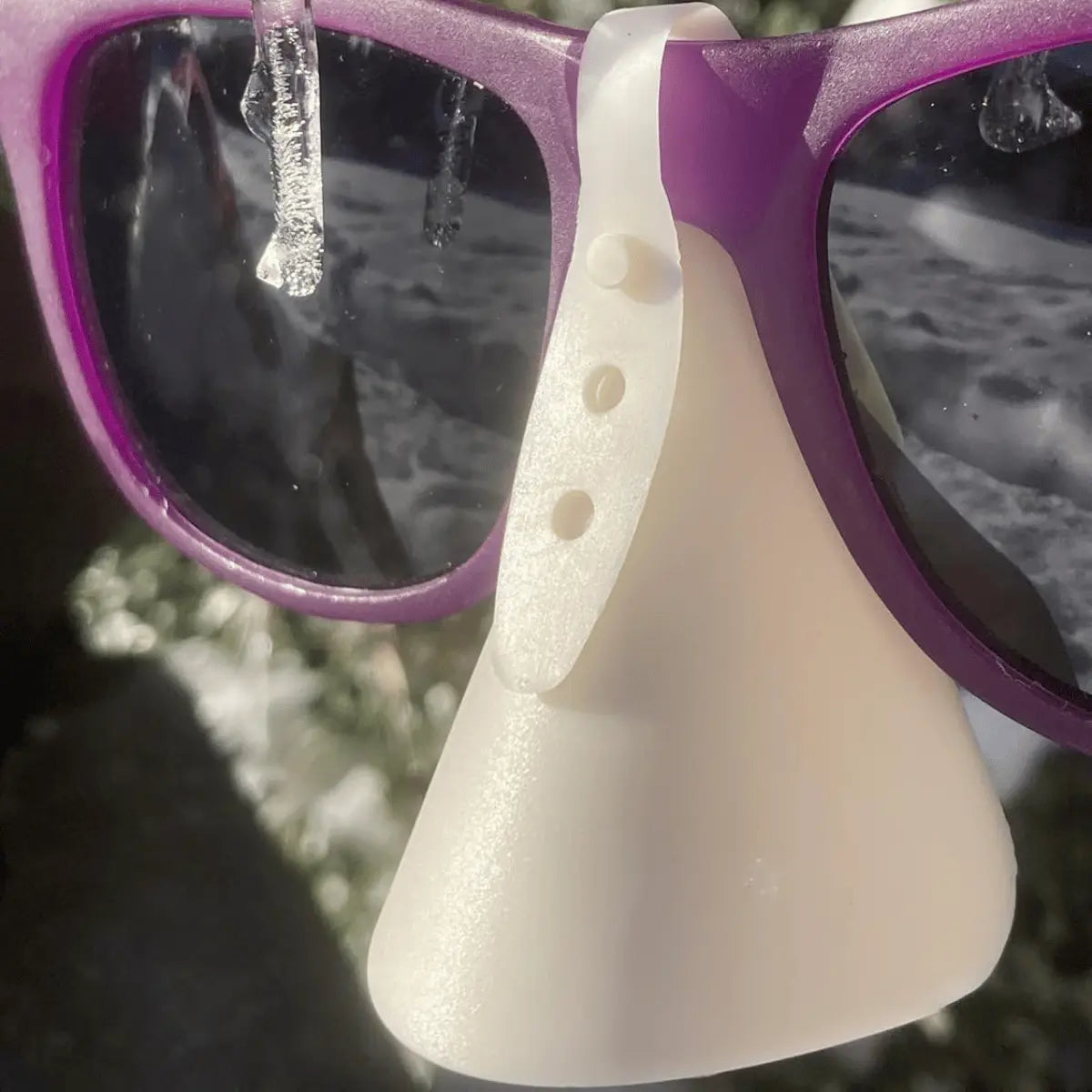 Nahaufnahme von lila Sonnenbrille mit Nasen Sonnenschutz, einem 3D-gedruckten weißen Aufsatz mit verstellbarem Band, ideal für Paragliding und Sonnenschutz.