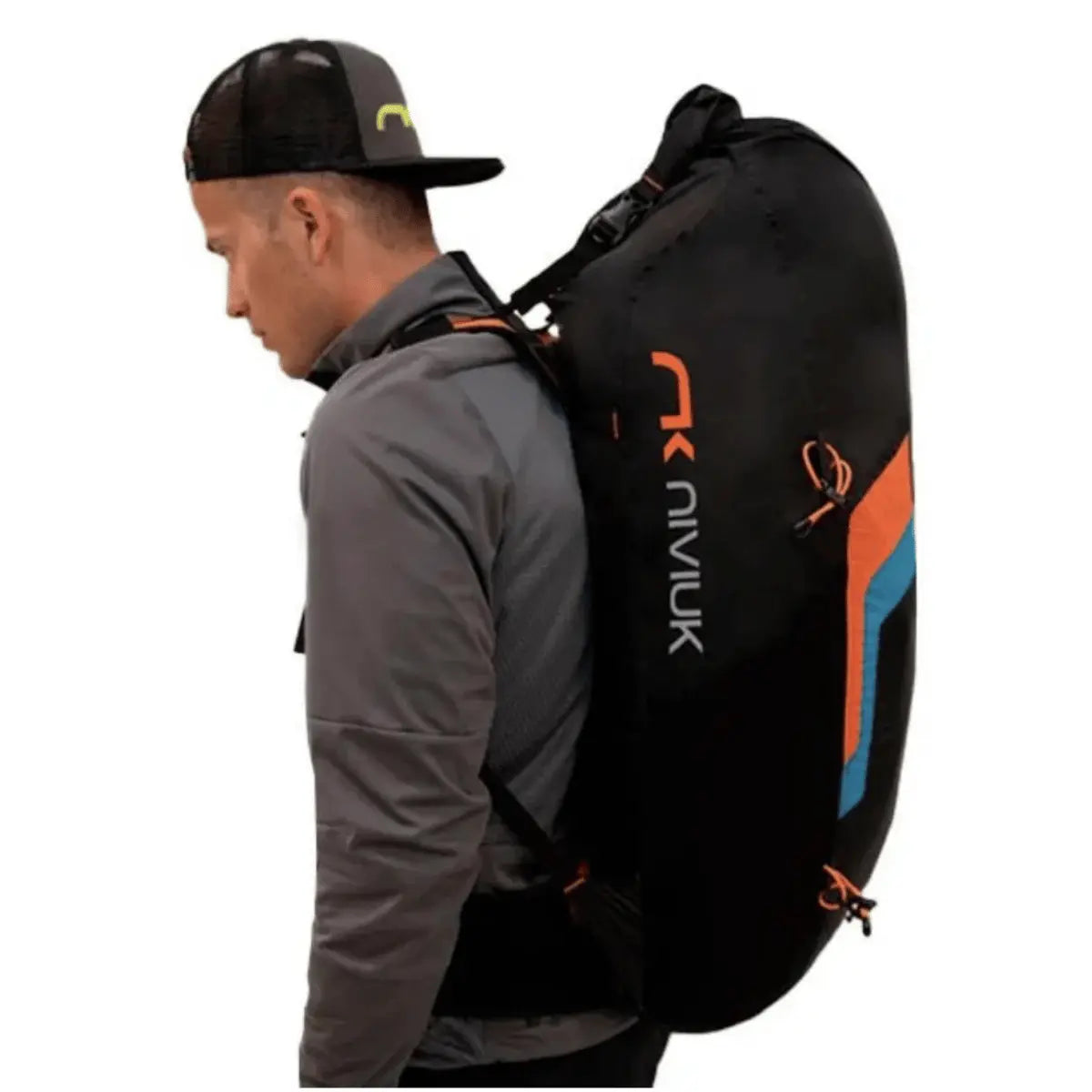 Ein Mann mit einem schwarzen Niviuk Expe Race Hike & Fly Rucksack, der auf dem Rücken getragen wird. Der Rucksack ist schwarz mit orangefarbenen und blauen Akzenten und hat eine große Kapazität.