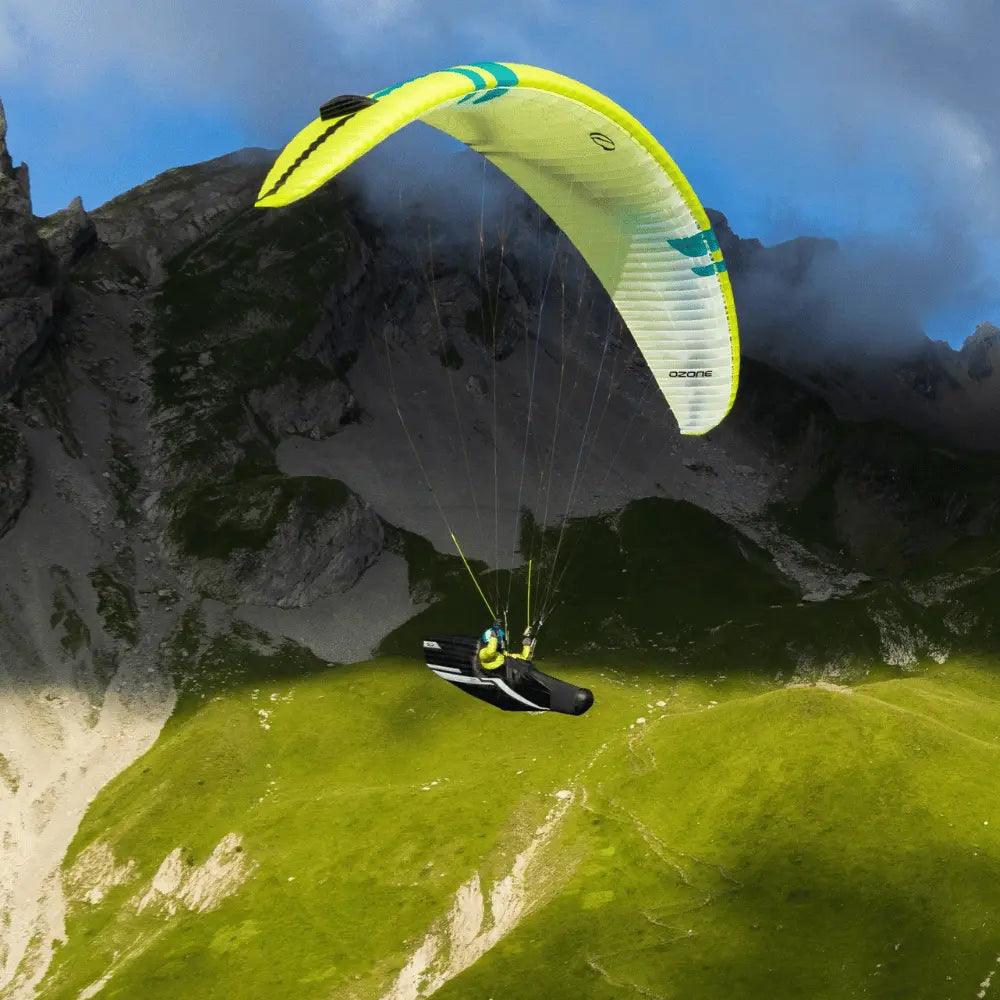 Ozone Alpina 5 (EN-C) Gleitschirm beim Paragliding über Berglandschaft, ideal für erfahrene Piloten, bekannt für leichtes Handling und hohe Leistung.