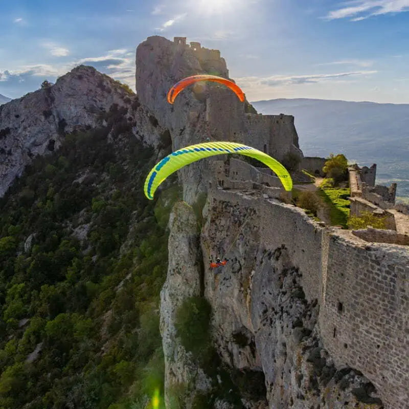 Ozone Buzz Z7 (Mid EN-B) Gleitschirm über felsiger Berglandschaft, ideal für XC-Flüge mit hoher passiver Sicherheit und neuester Technologie.