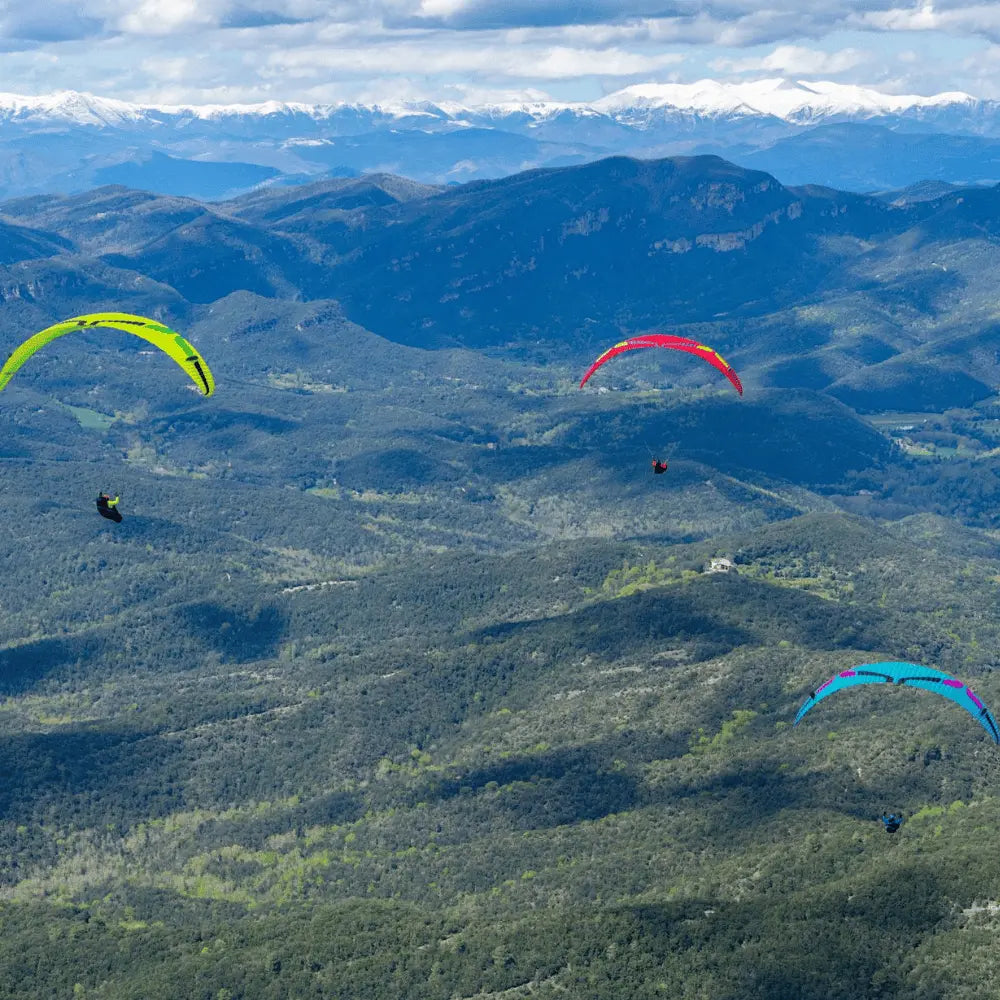 Ozone Delta 5 (EN-C) Gleitschirm, Nahaufnahme mehrerer bunter Schirme, bekannt für Leistung und sicheres Handling, ideal für erfahrene Piloten.