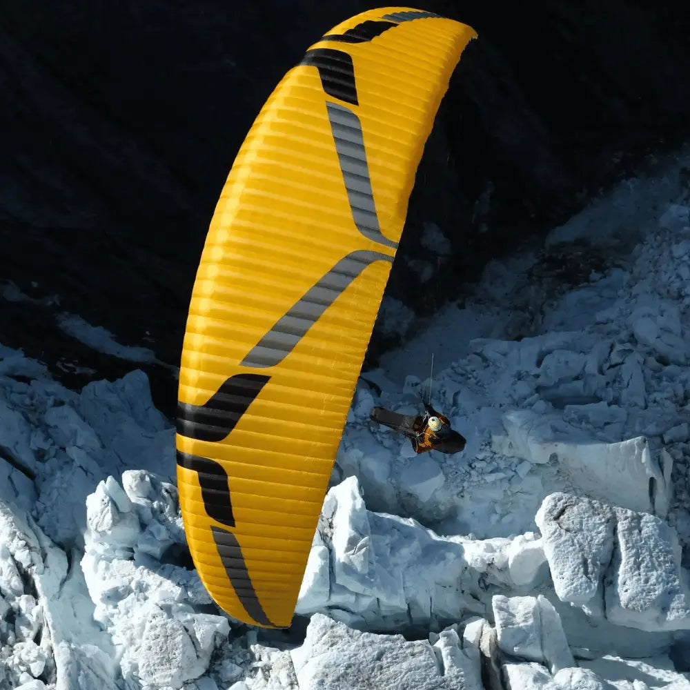 Ein Gleitschirmflieger mit einem Ozone Rush 6 (High EN-B) Schirm, der für hohe Leistung und Sicherheit beim Paragliding in der Luft sorgt.