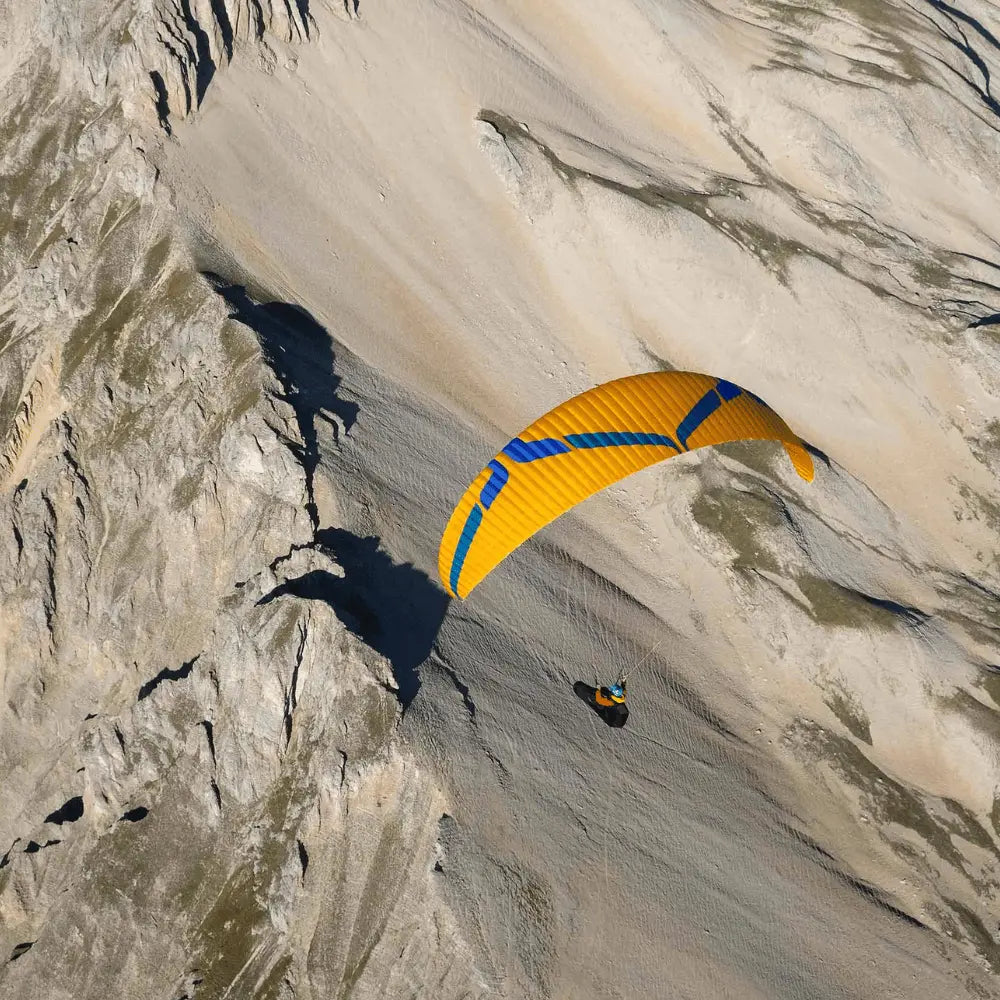 Person beim Paragliding mit Ozone Rush 6 Schirm, bekannt für hohe Leistung und Stabilität, in der Luft. Hochwertiges Produkt von Paragliding24.ch.