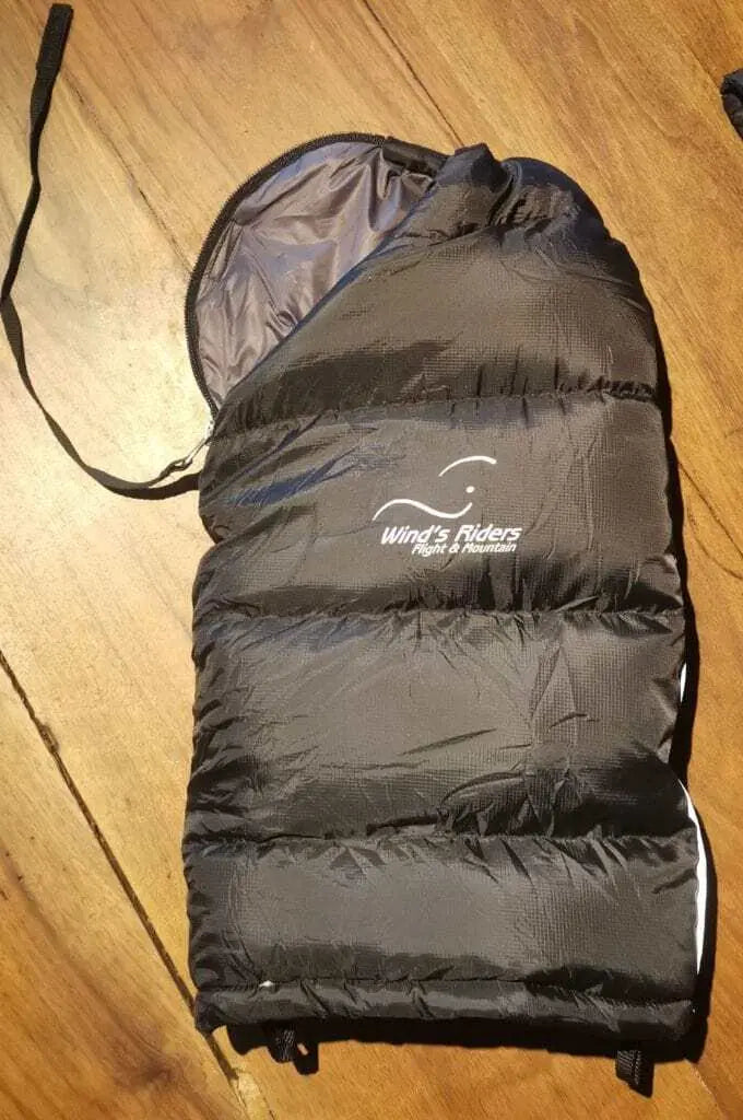 WindsRiders Warm Sleeve Muffles - Everest für extremen Kälteschutz beim Paragliding, abgebildet auf Holzoberfläche. Ideal für Flüge über hohe Bergketten.