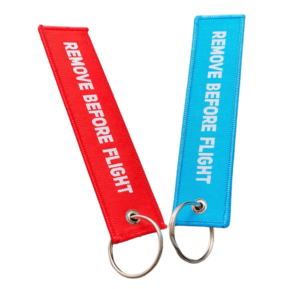 5-Punkte-Check Schlüsselanhänger mit Remove Before Flight-Text, rot und blau, hochwertig gewebt, ideal für Gleitschirmpiloten.