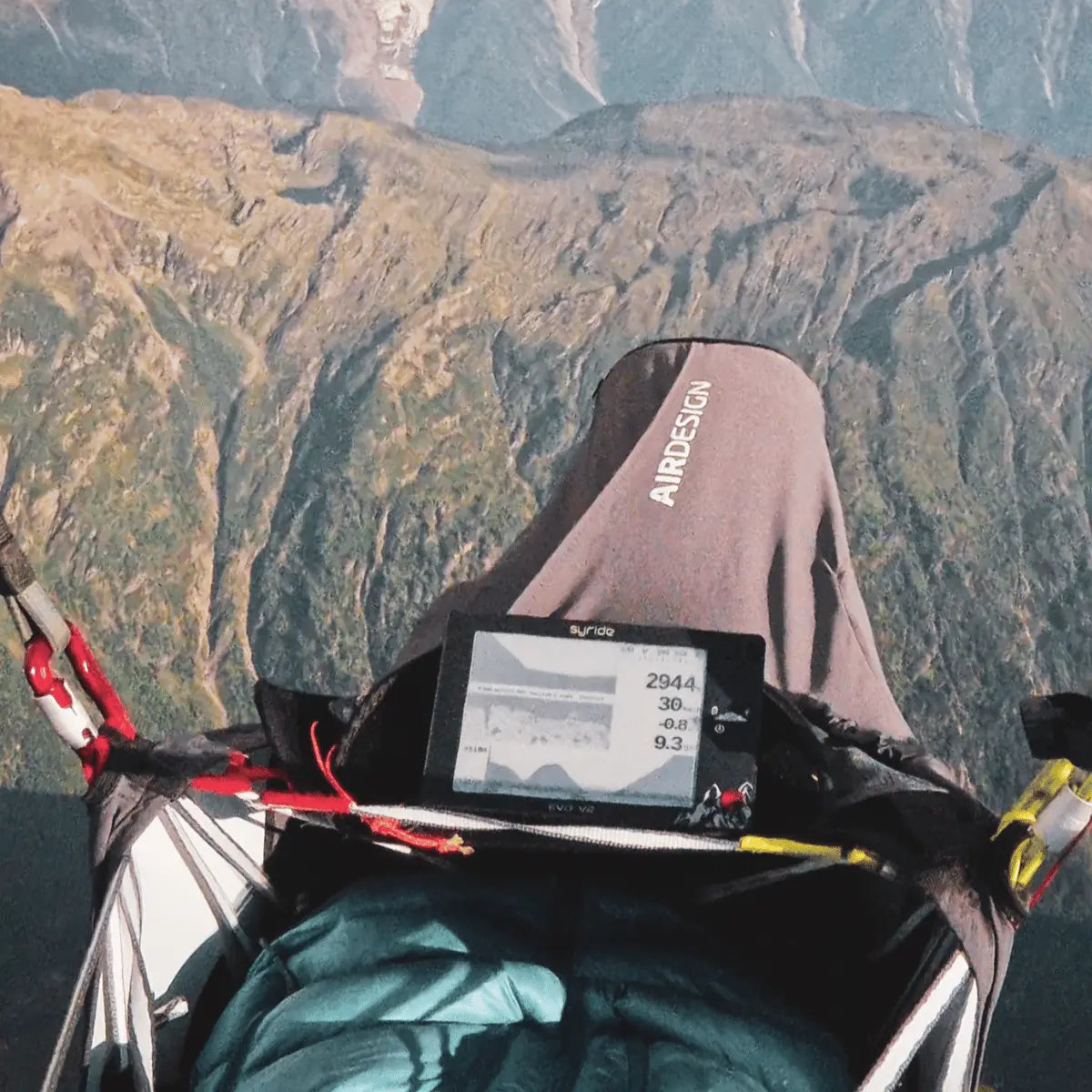 Syride Evo V2 Variometer in Flugausrüstung beim Gleitschirmfliegen über Berglandschaft, geeignet für Paragliding Enthusiasten und Hike & Fly Piloten.