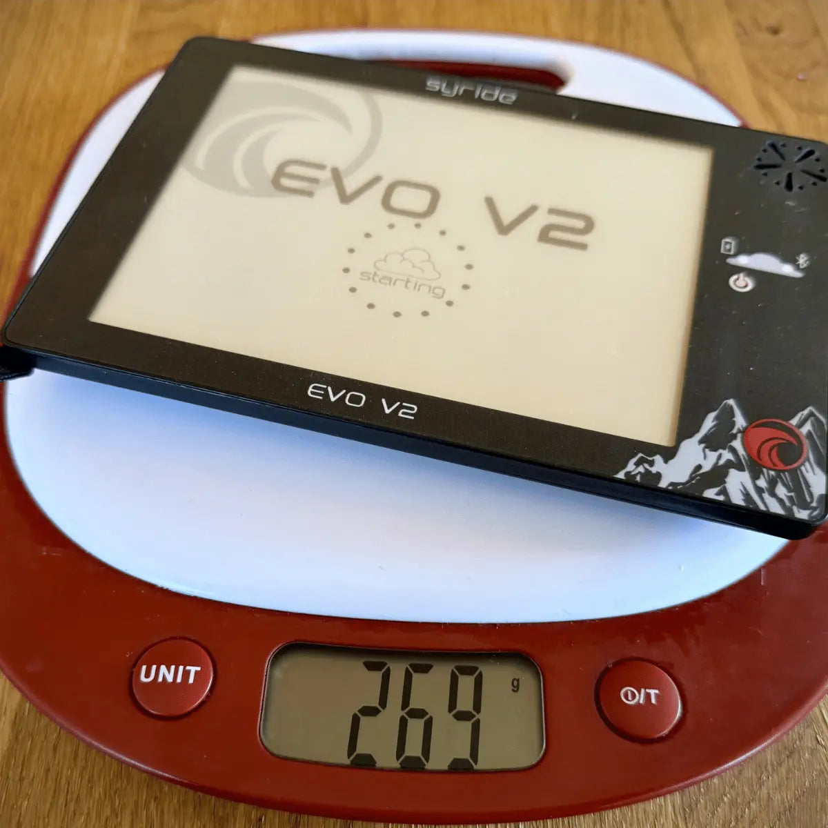 Das Syride Evo V2 Variometer für Gleitschirmflieger liegt auf einer Waage und zeigt ein Gewicht von 269 Gramm, ideal für Hike & Fly und Paragliding Einsätze.