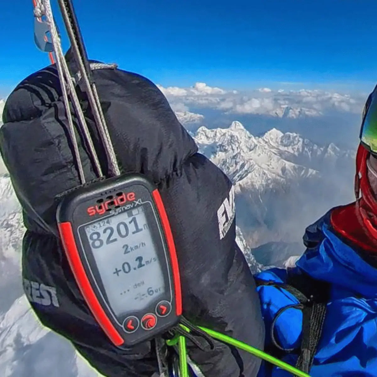 WindsRiders Everest Magnetic Muffles: Ein Mann in Bergsteigerkleidung mit einem Höhenmesser, der die Höhe von 8201 m anzeigt, vor einer atemberaubenden Bergkulisse.