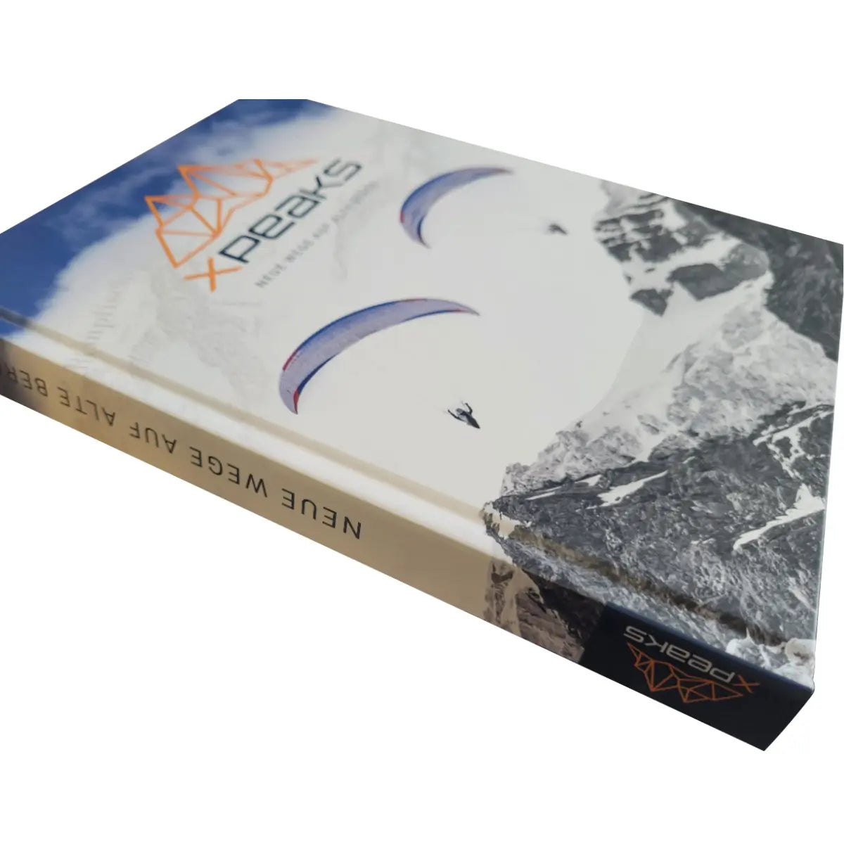 Buchcover von XPeaks mit dem Titel "Neue Wege auf alte Berge!", das Paraglider vor einer Bergkulisse zeigt.