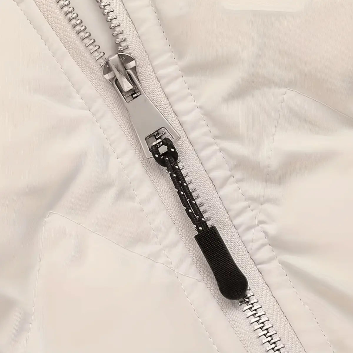 Silberner Reißverschluss mit schwarzem Kordelanhänger für Jacken, zeigt eine metallische Reißverschlussleiste und einen praktischen Zipper-Verlängerer.